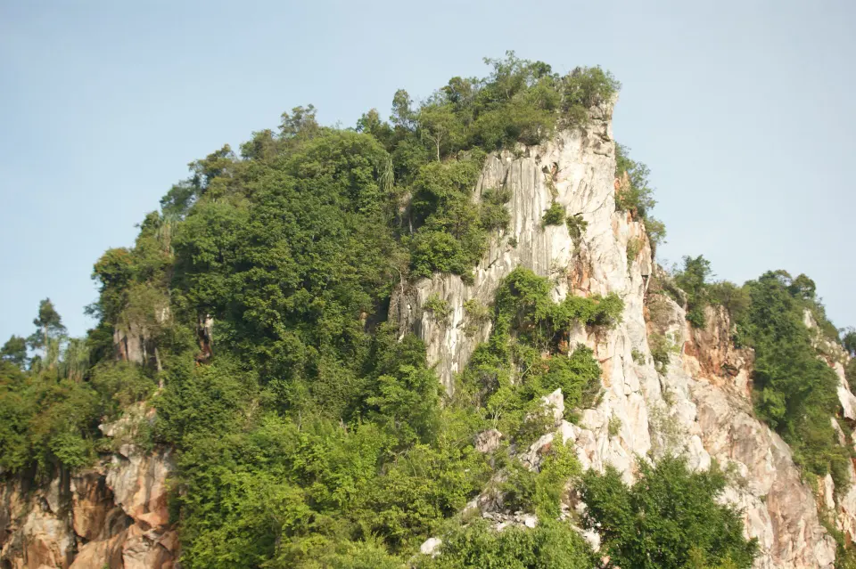 A limestone hill with sheer white cliffs and jungle on top, near Ipoh